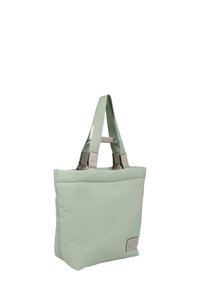 Lys grønn totebag med polstret design, som har to solide håndtak, sølvfarget maskinvare og en etikett med "STUDIO BERLIN" preget på.