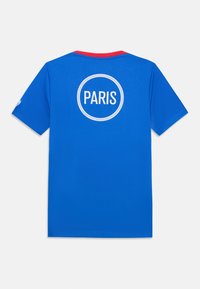 Blå t-skjorte med korte ermer og rød krage. Har et sirkulært hvitt design med ordet "PARIS" i midten på baksiden.
