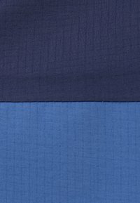 Tweekleurige stof met donkerblauw bovenaan en lichter blauw onderaan, beide met een subtiele rasterpatroonstructuur.