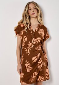 Vestito corto marrone con maniche corte, colletto con bottoni e motivi a foglie pesca. Presenta un design avvolgente con un dettaglio di legatura laterale.