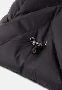 Sort quiltet stof med en sort snoretræk med sølv metal hardware og "Bogner" branding.