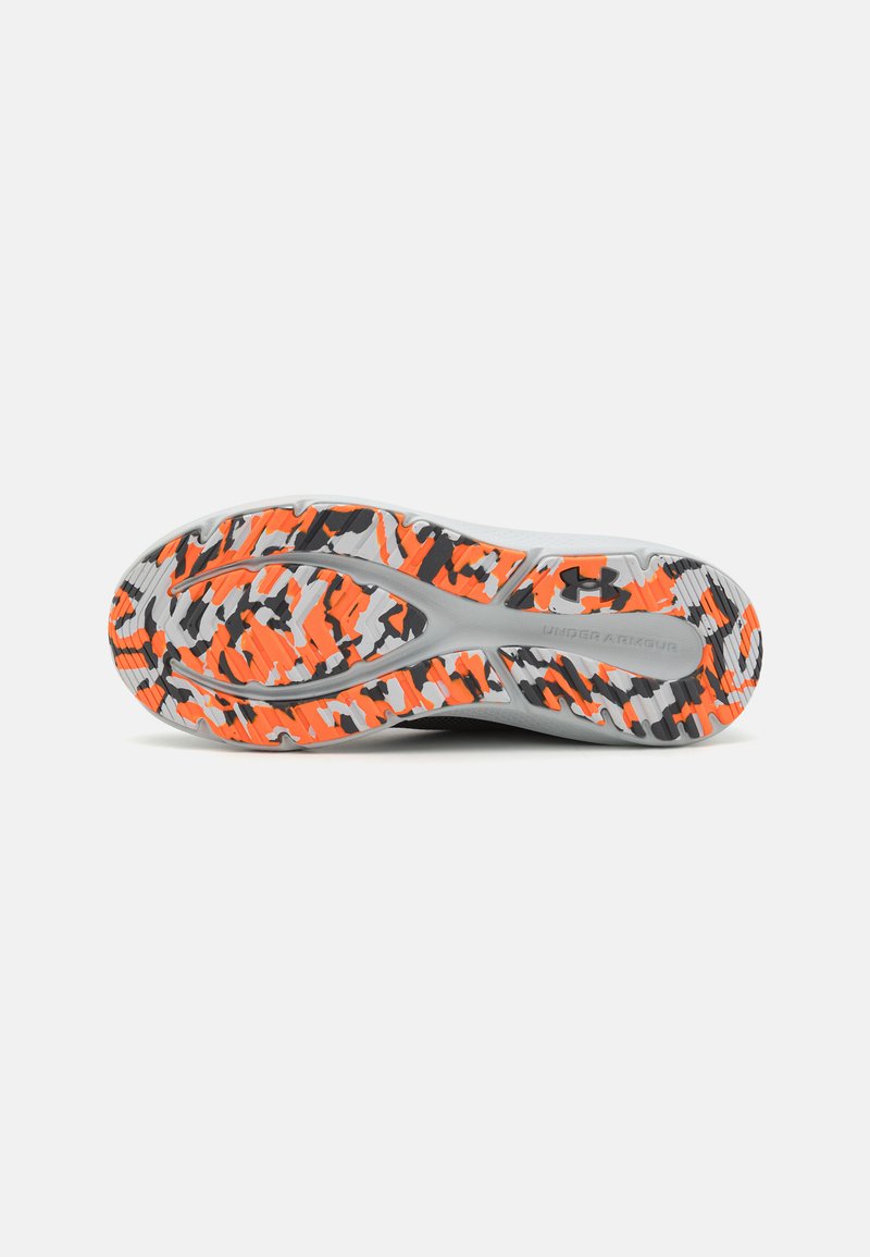 Semelle de chaussure de sport présentant un motif multicolore d'orange, de noir et de gris, avec des rainures texturées pour une meilleure adhérence.