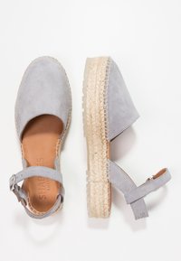 Šedé semišové espadrilky na sandály s pletenou jutu podešví, otevřenou špičkou, kotníkovým páskem se sponou a hladkou koženou stélkou.