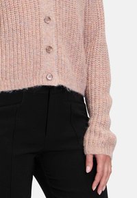 Helles rosafarbenes Strickjacke aus strukturiertem Stoff, mit einem verkürzten Saum, gerippten Bündchen und fünf Holzknöpfen auf der Vorderseite.