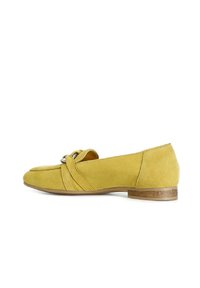 Zapato plano de ante amarillo con punta redonda y detalle decorativo de nudo en la parte superior. Presenta un tacón bajo de madera para mayor estabilidad.