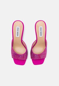 Talons escarpins fuchsia avec un bout carré plat et une sangle texturée ornée de bijoux. Doublure intérieure lisse et découpe au niveau de la cheville pour un style supplémentaire.