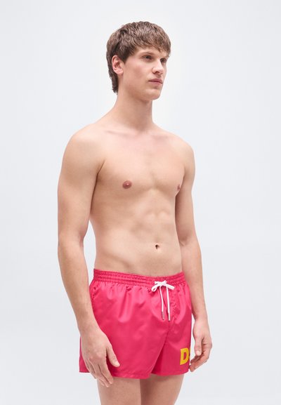 Κόκκινα μαγιό βερμούδα από ελαφρύ υλικό, με ελαστική μέση και λευκό κορδόνι, διακοσμημένα με έντονο κίτρινο λογότυπο.