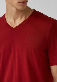 Czerwony bawełniany t-shirt z dekoltem w serek, z subtelnym logo s.Oliver na piersi, krótkimi rękawami i gładką fakturą.