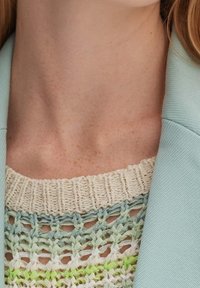 Knitted top with textured cream, mint green, and pale blue yarns; features a wide neckline and is paired with a light blue blazer.