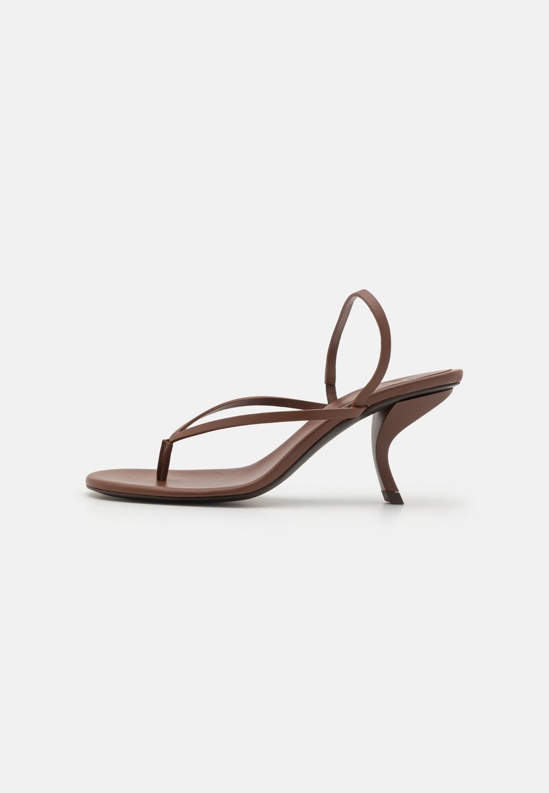 Sandalia marrón con diseño de tira entre los dedos, correas delgadas y un tacón curvado alto. Textura suave y estilo minimalista, adecuada para un uso casual.