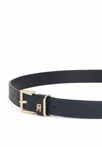 Cinturón de cuero azul marino con un patrón texturizado, hebilla en tono dorado y acento con el logo. Presenta un forro interior suave y un diseño de hebilla rectangular.