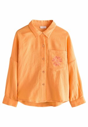 Chemise orange à texture, boutonnée avec un col, une poche poitrine unique et des détails de broderie florale. Tissu doux, coupe décontractée.
