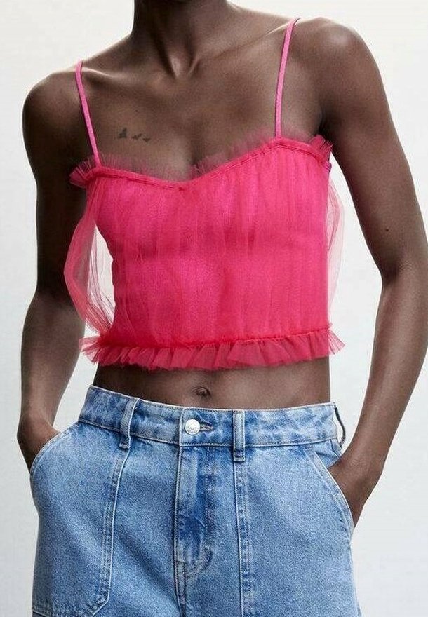 Top corto rosa transparente con tirantes finos, dobladillo con volantes y una textura suave, combinado con shorts de mezclilla de tiro alto en azul claro.