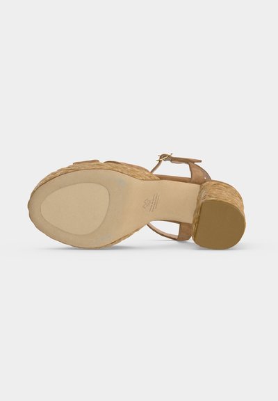 Sandale avec texture tissée, talon bloc, bride à la cheville et semelle en caoutchouc vue de dessous sur fond blanc.