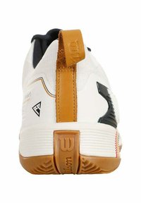 Scarpa sportiva bianca con tomaia bianca testurizzata, dettagli neri, un inserto in cuoio marrone sul tallone e una suola in gomma con un motivo di grip pronunciato.