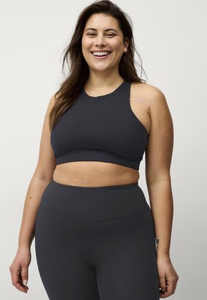 Donkergrijze sportieve crop top met hoge hals en racerback ontwerp, gecombineerd met hoge taille legging in dezelfde stijl. Glad, elastisch materiaal.