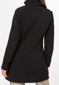 Manteau imperméable noir avec un col montant, des manches longues et une coupe ajustée. Caractérisé par des accents de coutures et une texture lisse et mate.