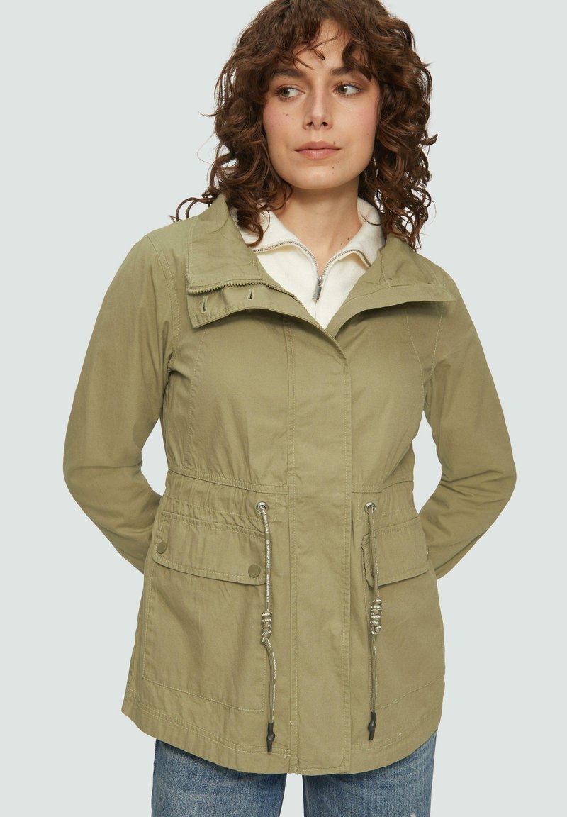 Giacca verde chiaro con zip anteriore, vita regolabile con cordino e due tasche davanti. Realizzata in un tessuto liscio e resistente.