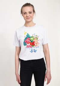 Vit bomullströja med en färgglad grafik av två björnar, ett träd, musiknoter och två blåfåglar på en snöig mark.