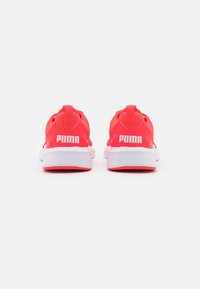Světlé růžové sportovní boty s prodyšnou síťovinou, bílé podrážky a výrazným logem "PUMA" na patě. Obsahují poutko v zadní části.