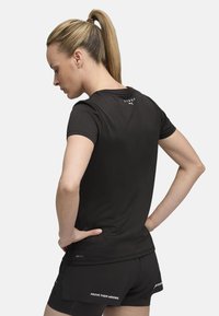 Black athletic t-shirt made of breathable material with short sleeves. Features printed branding on the back and "PROVE THEM WRONG" detail on shorts.