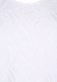 Tissu blanc texturé présentant un motif en vagues avec des crêtes surélevées et une surface douce et tactile. Pas de matériel ou d'accents visibles.