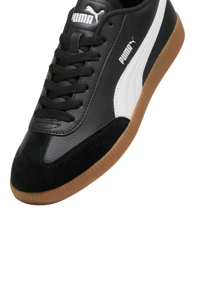 Zapatillas de cuero en blanco y negro con acentos de ante y suela de goma, que presentan un diseño de cordones y un detalle del logo en el lateral.