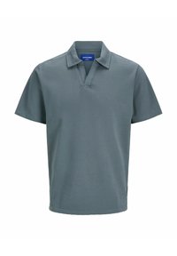 Polo gris avec un col court, des manches courtes et un tissu texturé. Présente une étiquette logo sur le côté gauche près de l'ourlet.