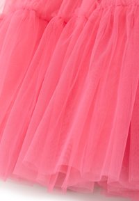 Tejido de tul rosa con volantes en capas, que presenta una textura de malla fina y una apariencia suave y ligera. No hay hardware ni patrones notables visibles.