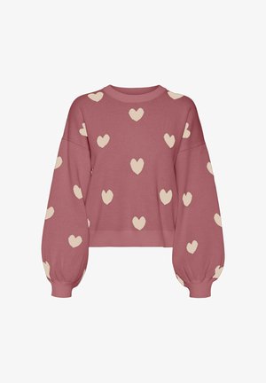 Lyserød strikket sweater med overdrevne, puffede ærmer. Dekoreret med crèmefarvede hjerte-mønstre overalt. Ribbet rund hals og kant.