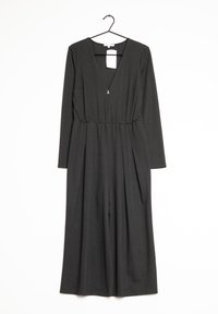Mono negro con mangas largas, escote en V, cintura elástica y piernas anchas; cuenta con un pequeño acento dorado y una etiqueta de venta adjunta.