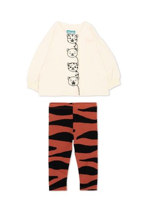 Chemise crème à manches longues avec quatre visages d'animaux noirs et blancs sur le devant, associée à des leggings rayés tigre marron et noir.