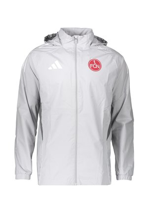 Chaqueta deportiva blanca con cremallera y capucha, logo de Adidas en el pecho derecho y emblema circular rojo de 1. FCN en el pecho izquierdo.