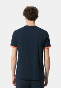 T-shirt blu navy a maniche corte con bordi arancioni a contrasto nei polsini. Realizzato in tessuto morbido, presenta un colletto rotondo e un logo sulla manica.