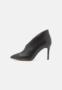 Black leather high-heeled shoe with a pointed toe, smooth texture, and a sleek design. Features a narrow opening at the front and a slim heel.