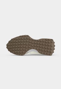 Semelle de chaussure avec semelle extérieure en caoutchouc marron avec des crampons ronds pour l'adhérence, vue de dessous sur fond blanc.