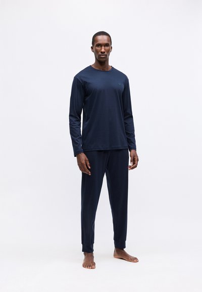 Blandade långärmade pyjamas set i marinblått gjort av mjukt tyg, med rundad halsringning och avsmalnande byxor med ankelfållar. Minimalistisk design, utan mönster.