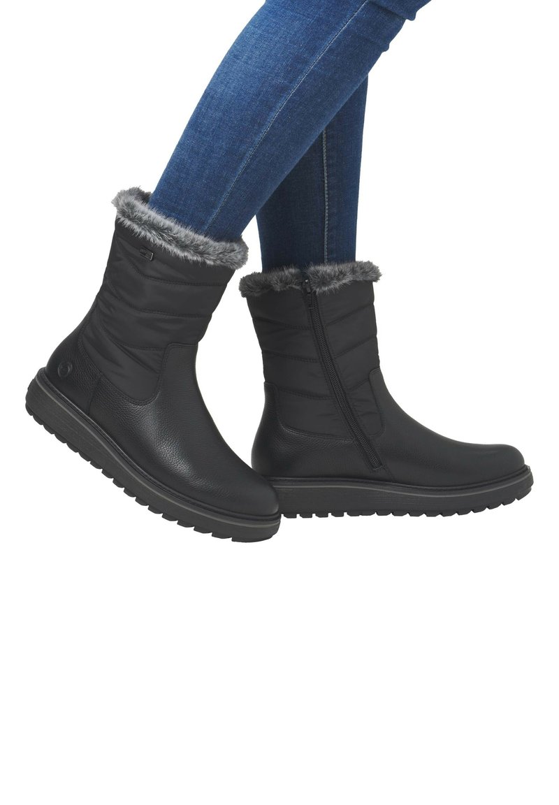 Schwarze Ankle Boots aus Leder und Textil mit einem grauen Kunstfellkragen, Reißverschluss und strukturierten Gummisohlen für besseren Halt.