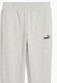 Grå sweatpants med elastisk midjeband. Har en svart Puma-logotyp på vänster sida. Tillverkad av mjukt, texturerat tyg.