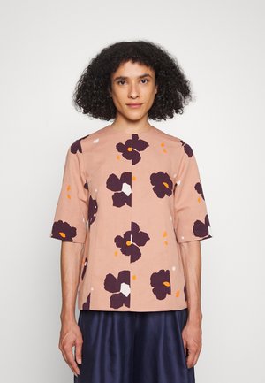 Top de manga curta em tecido rosa suave com padrão floral roxo escuro, detalhes em laranja e branco, decote redondo, corte reto.