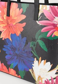 Zwarte tote bag met levendige bloemenpatronen in oranje, roze, blauw en wit. Textuurmateriaal met reliëf "BAKER LONDON" logo.