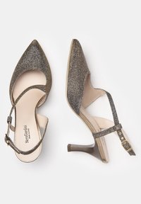 Sandales à talons hauts métalliques gris avec bouts pointus, brides de cheville et accents brillants. Doublure intérieure lisse et matériau extérieur texturé.
