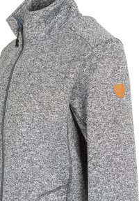 Veste en maille grise avec col haut, fermeture éclair et tissu texturé. Présente un écusson en cuir tan sur l'épaule.