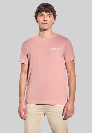 Lichtroze katoenen T-shirt met korte mouwen en een ronde halslijn, met een wit tekstlogo op de linkerborst. Glad textuur.