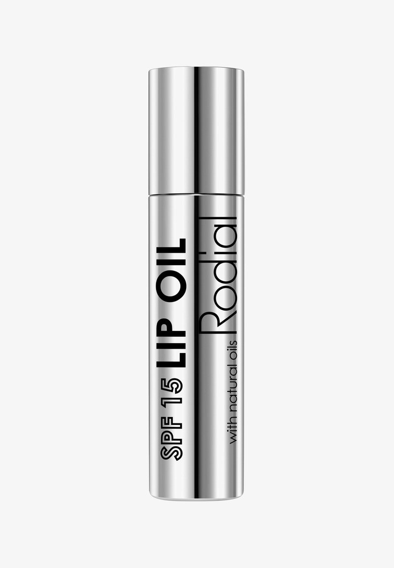 Silberner zylindrischer Lippenölbehälter, beschriftet mit "SPF 15 LIPPENÖL" und "Rodial", in schwarzer Schrift und mit einer glatten, metallischen Oberfläche.