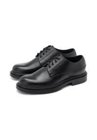 Chaussures en cuir noir à lacets avec un bout arrondi, texture lisse et semelle en caoutchouc solide. Présente six œillets et une couture minimale.