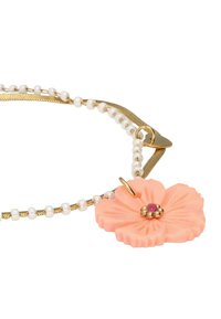 Collier en chaîne dorée avec des perles blanches et un pendentif en forme de fleur rose comportant un petit gemme central et des détails dorés.