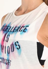 Biała, bezrękawnikowa bluzka z gradientem różowo-niebieskich odcieni, z czarnym napisem: "EXCELLENCE IS OBVIOUS C.R. CROSSFIT."