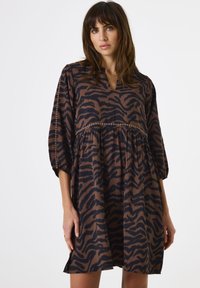Bruin en zwart zebra print jurk met een V-hals, driekwart mouwen en een geraffineerde taille. Zachte stof met een lichte glans.