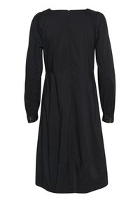 Crna haljina dugih rukava izrađena od glatke tkanine, s okruglim izrezom, gurnutim strukom i dugmadi na manžetama. Zatvaranje na patentni zatvarač na leđima.